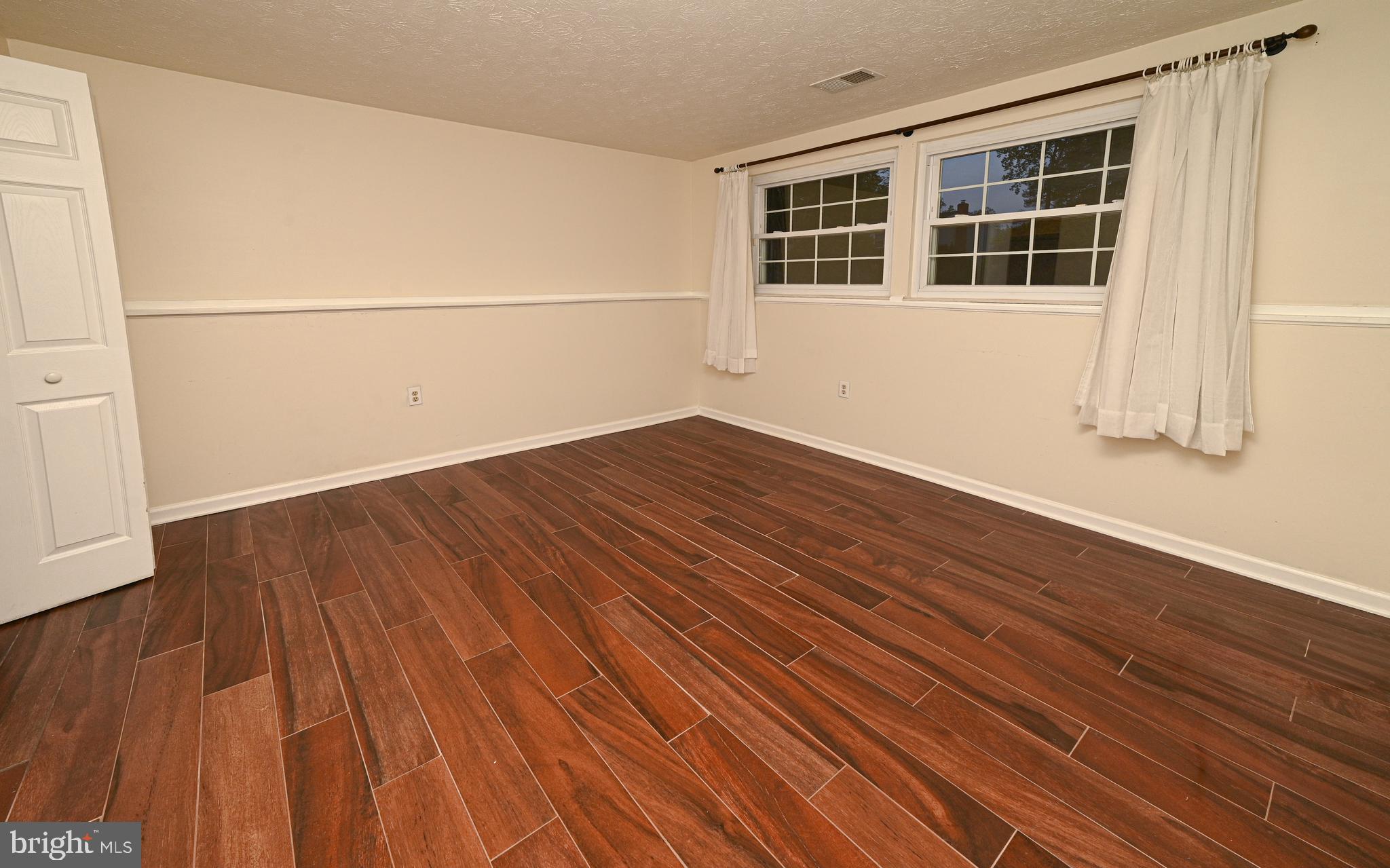 8110 Winter Blue Court Springfield, VA 22153 - Photo 20 of 24 a view of an empty room with wooden floor and a window