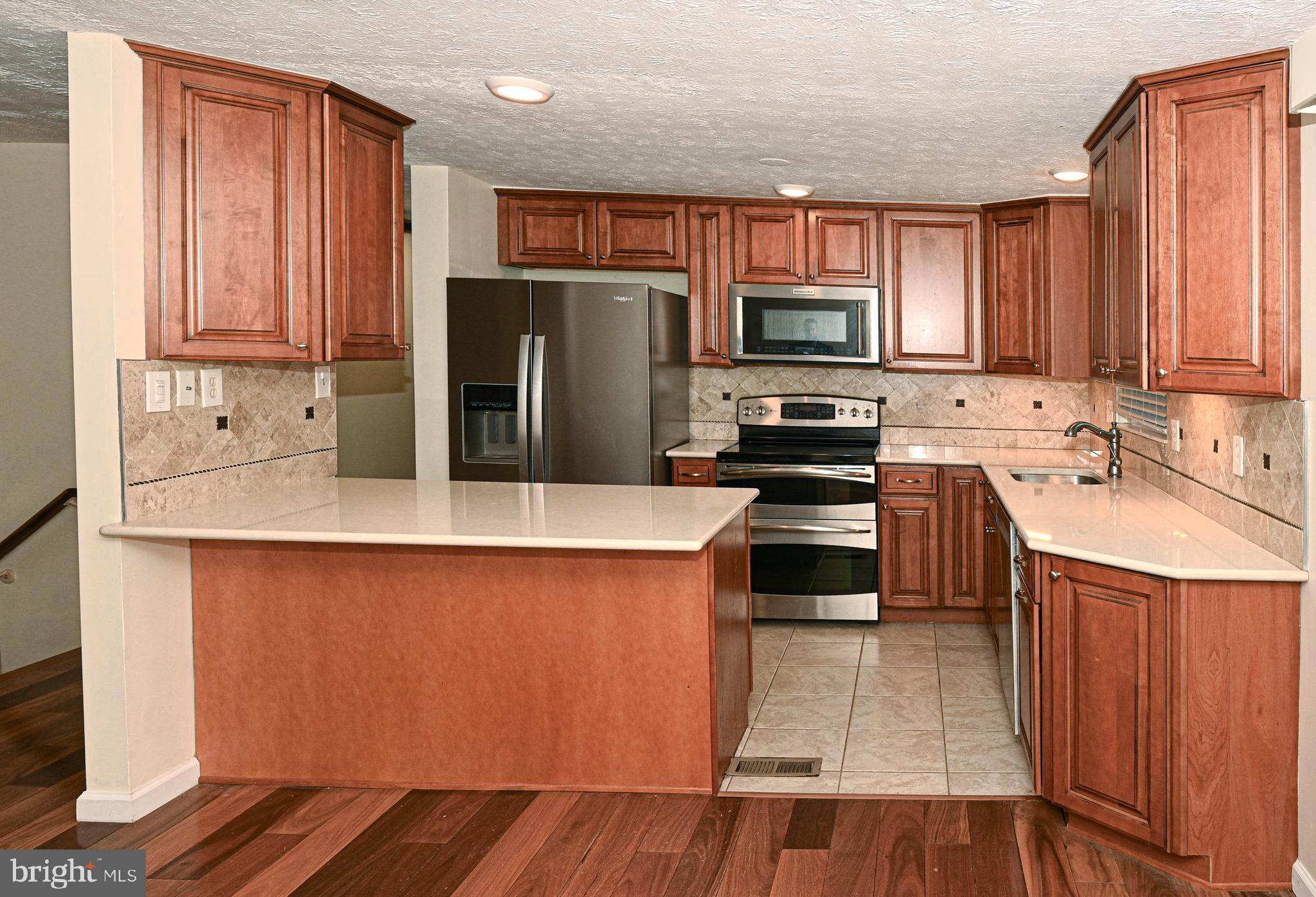 8110 Winter Blue Court Springfield, VA 22153 - Photo 6 of 24 a kitchen with stainless steel appliances a stove a sink and a refrigerator