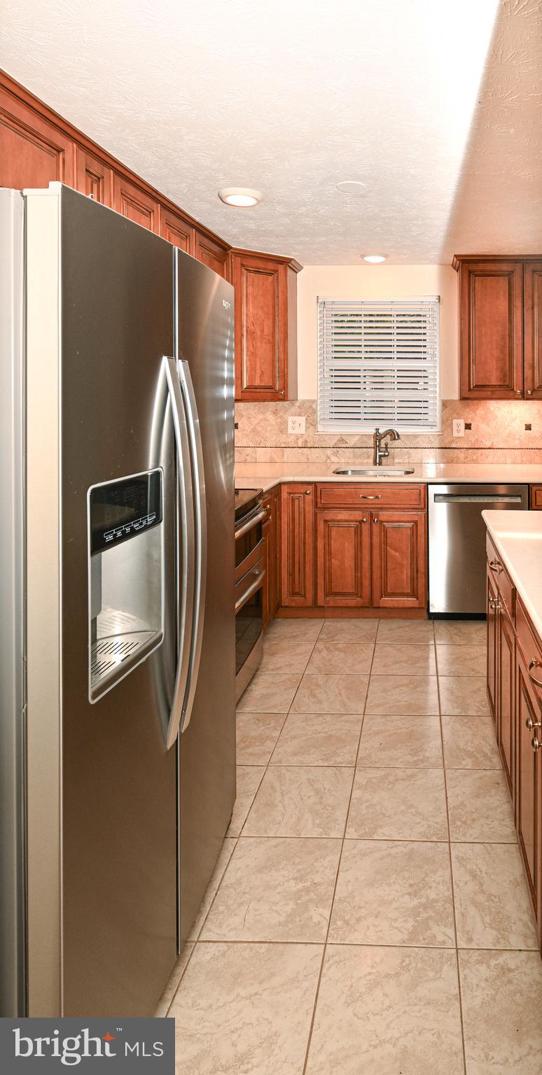 8110 Winter Blue Court Springfield, VA 22153 - Photo 8 of 24 a kitchen with stainless steel appliances granite countertop a refrigerator and a stove top oven