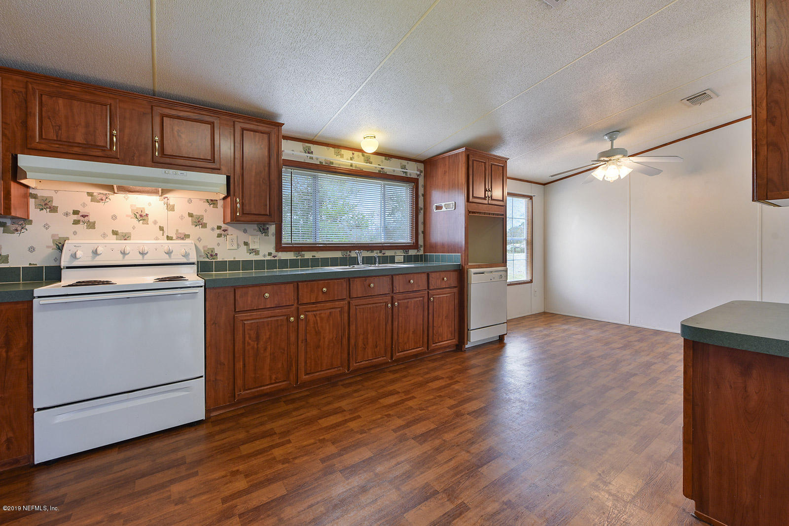 75302 Edwards Road Yulee, FL 32097 - Photo 11 of 25 a kitchen with granite countertop wooden floors and white stainless steel appliances