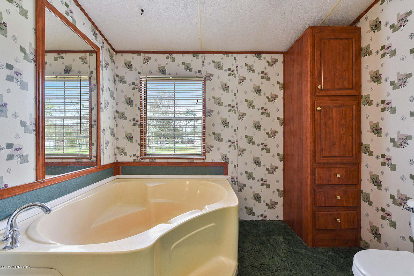 75302 Edwards Road Yulee, FL 32097 - Photo 14 of 25 a bathroom with a bathtub and window