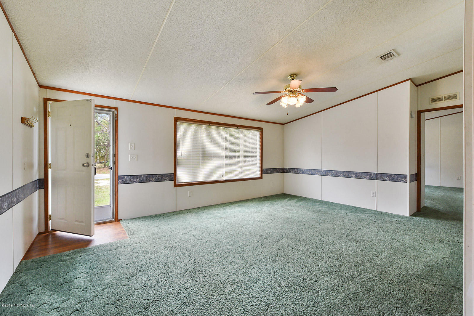 75302 Edwards Road Yulee, FL 32097 - Photo 5 of 25 an empty room with windows and fan