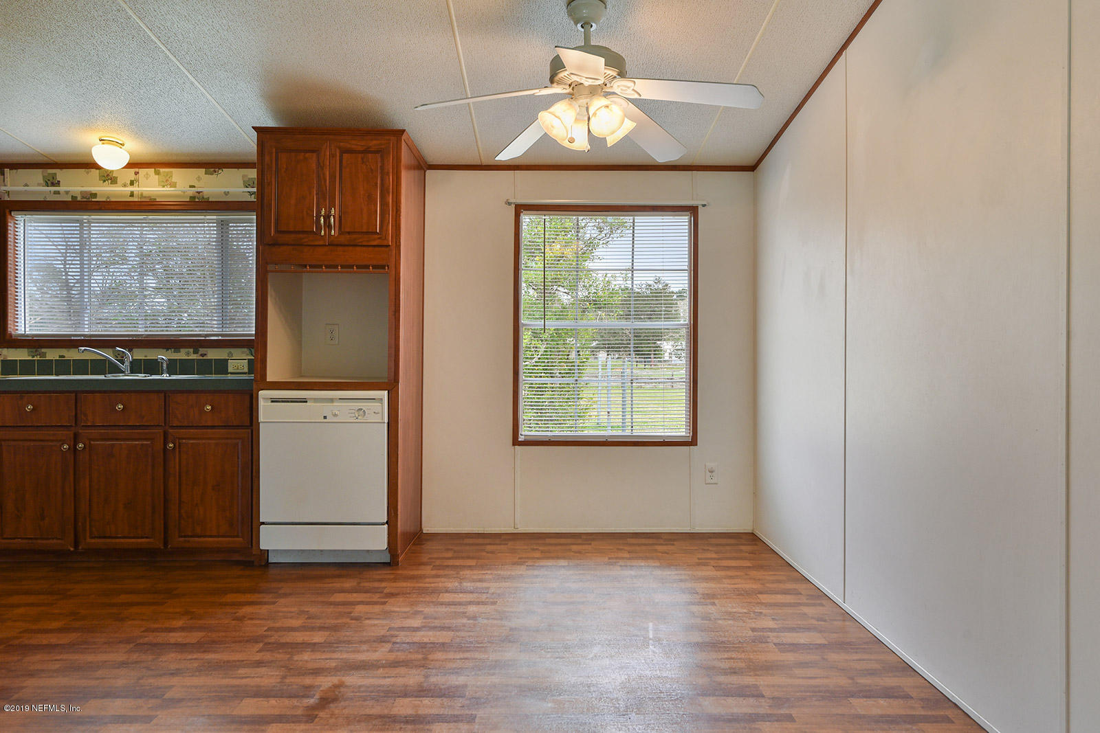 75302 Edwards Road Yulee, FL 32097 - Photo 8 of 25 an empty room with wooden floor cabinet and windows