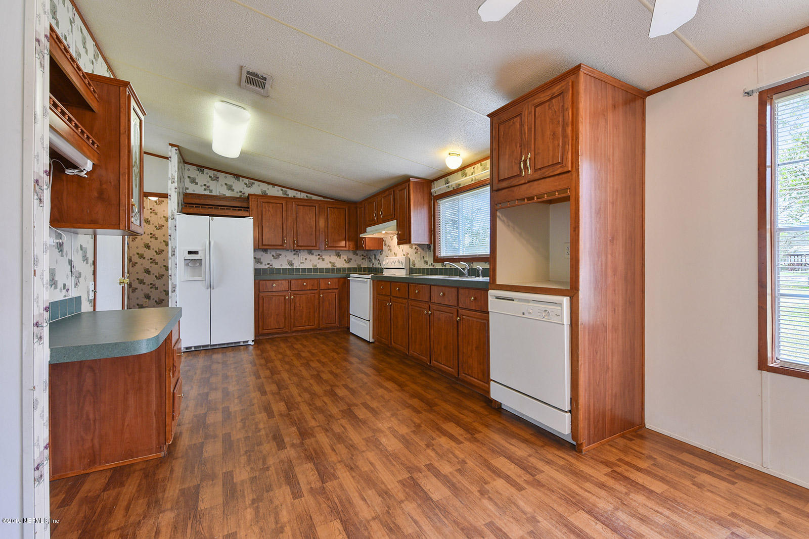 75302 Edwards Road Yulee, FL 32097 - Photo 9 of 25 a kitchen with stainless steel appliances a refrigerator and wooden floor