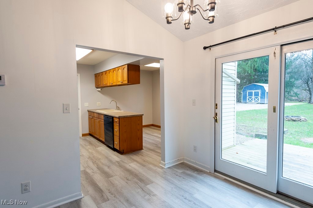 11819 Sheldon Road Mantua, OH 44255 - Photo 7 of 46 Dining area with luxury vinyl plank floors, lofted ceiling, an inviting chandelier, and sliding glass doors that lead to the deck outside.