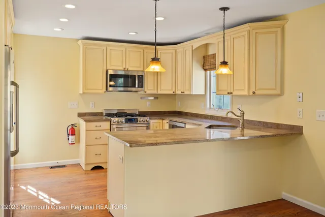 a kitchen with stainless steel appliances granite countertop a sink a stove and a refrigerator