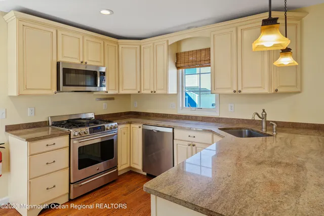 a kitchen with stainless steel appliances granite countertop a sink stove and microwave