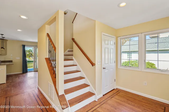 a view of a livingroom with wooden floor and stairs