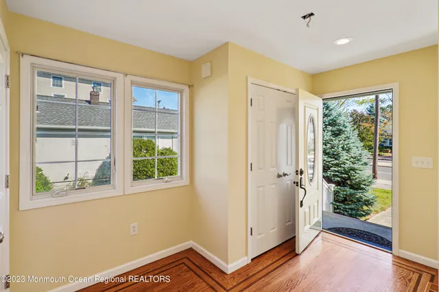 a view of a hallway with wooden floor and cabinet