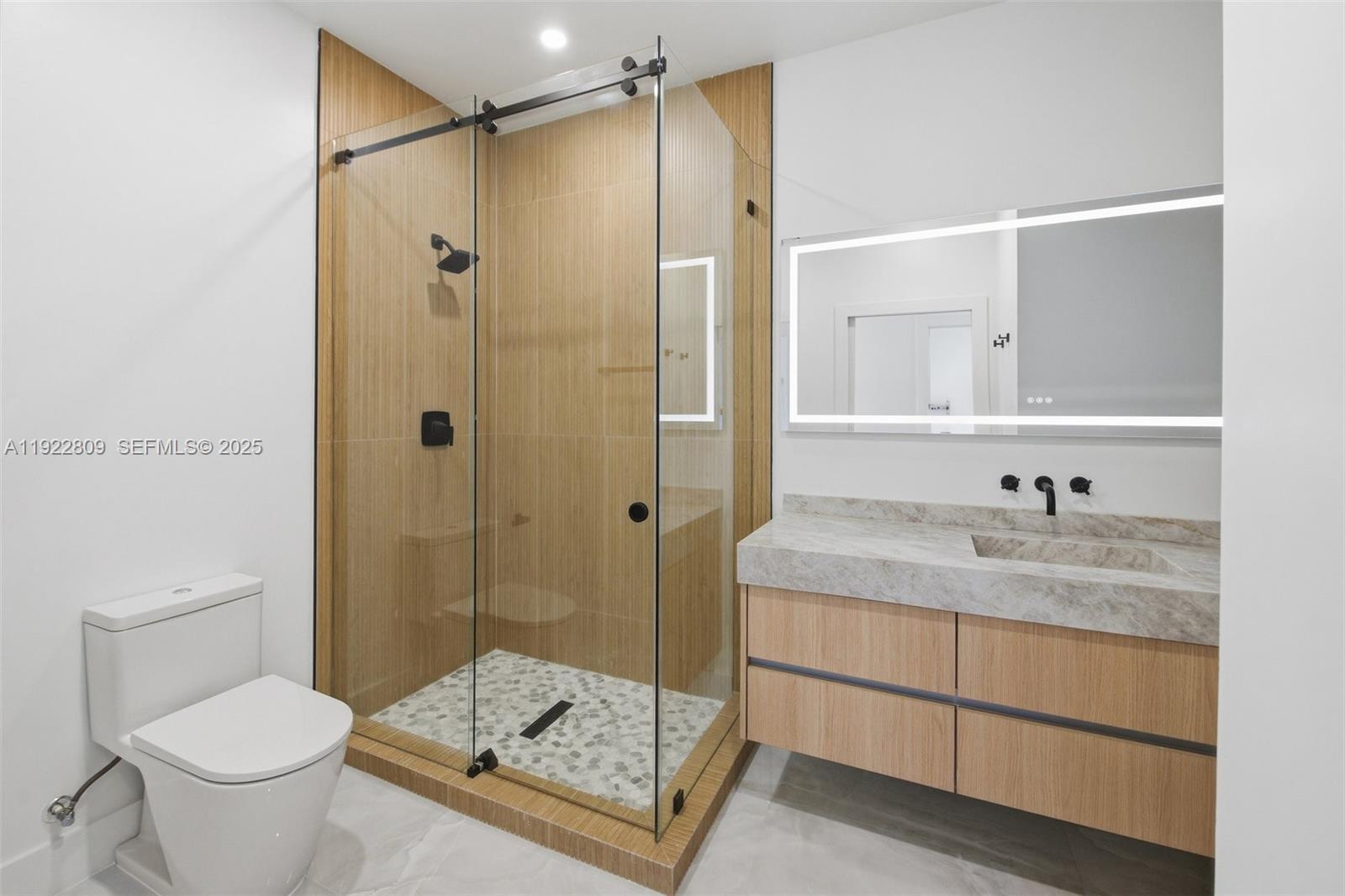 3111 Southwest 12th Street, Unit A Miami, FL 33135 - Photo 22 of 35 a bathroom with a granite countertop sink a toilet and shower