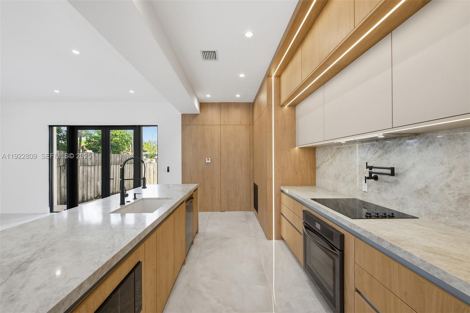 3111 Southwest 12th Street, Unit A Miami, FL 33135 - Photo 6 of 35 a large kitchen with granite countertop a large counter top and stainless steel appliances