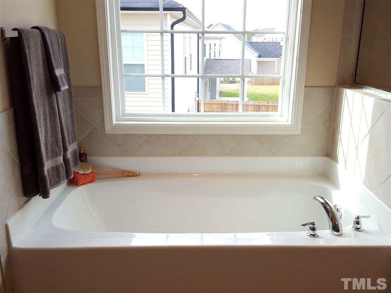 7613 Channery Way Raleigh, NC 27616 - Photo 14 of 25 a bathroom with a bathtub and a window