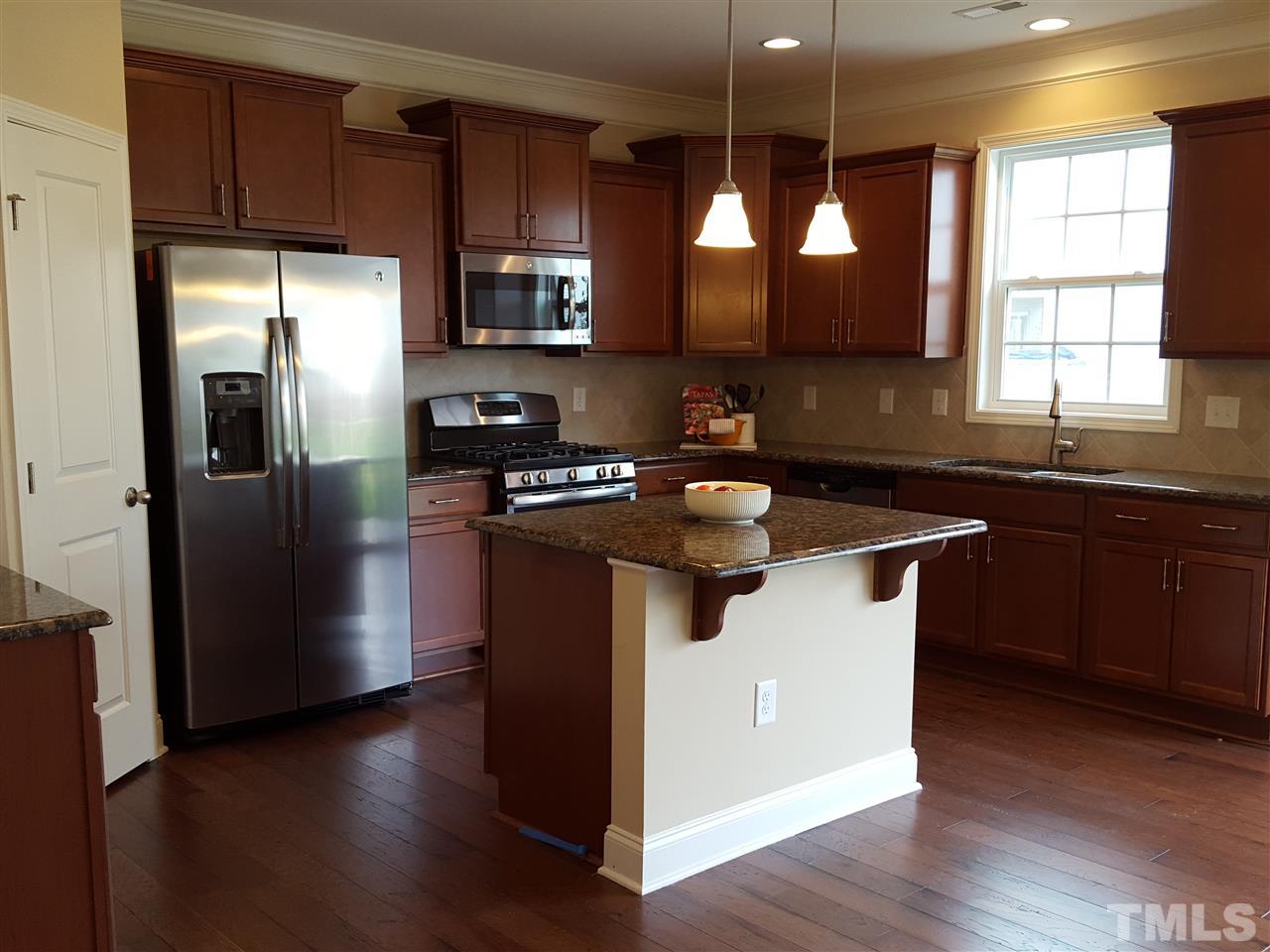 7613 Channery Way Raleigh, NC 27616 - Photo 6 of 25 a kitchen with stainless steel appliances granite countertop a sink a stove a refrigerator and wooden floor