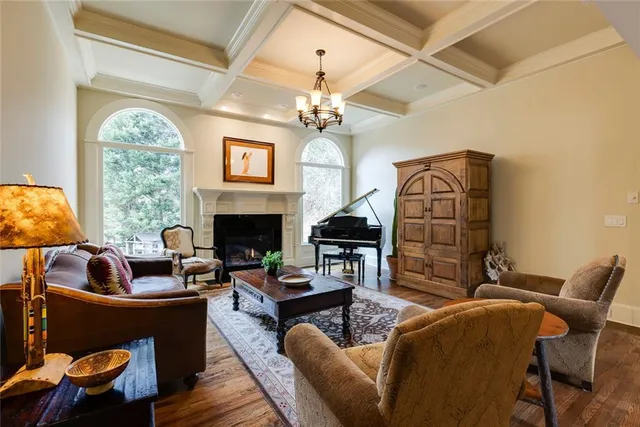 a living room with furniture a fireplace and a chandelier