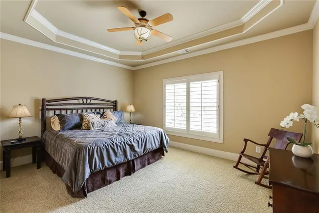 a bedroom with a bed a chair and a chandelier