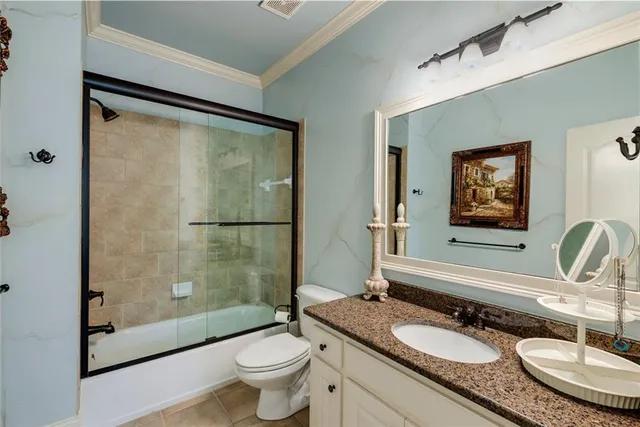 a bathroom with a granite countertop sink mirror vanity and toilet