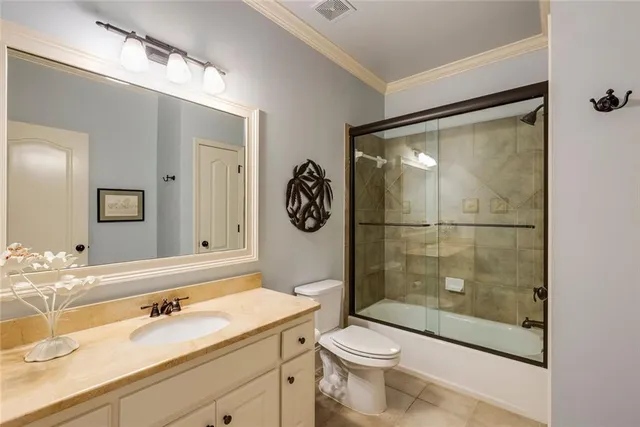 a bathroom with a granite countertop sink a mirror a toilet and shower