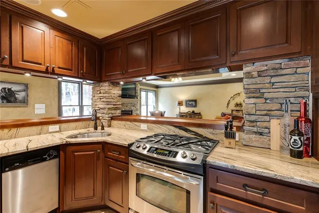 a kitchen with stainless steel appliances granite countertop a stove and a sink