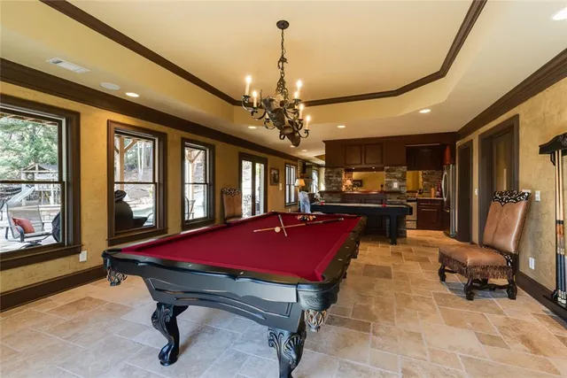 a room with pool table and windows