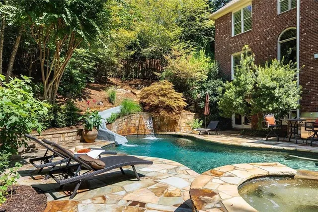 a view of a house with swimming pool and sitting area
