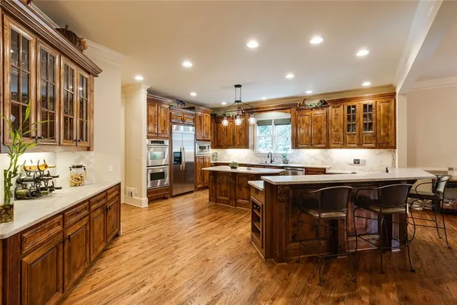a kitchen with stainless steel appliances granite countertop a stove and a wooden floors