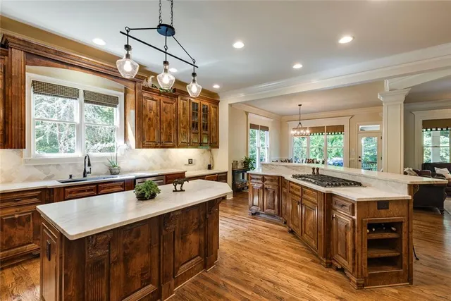 a large kitchen with kitchen island a sink stainless steel appliances and furniture