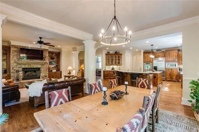a view of a dining room and livingroom with furniture wooden floor a chandelier