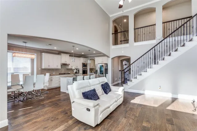 a living room with furniture and a dining table with wooden floor
