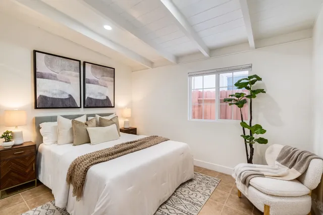 a bedroom with a bed chair and potted plant