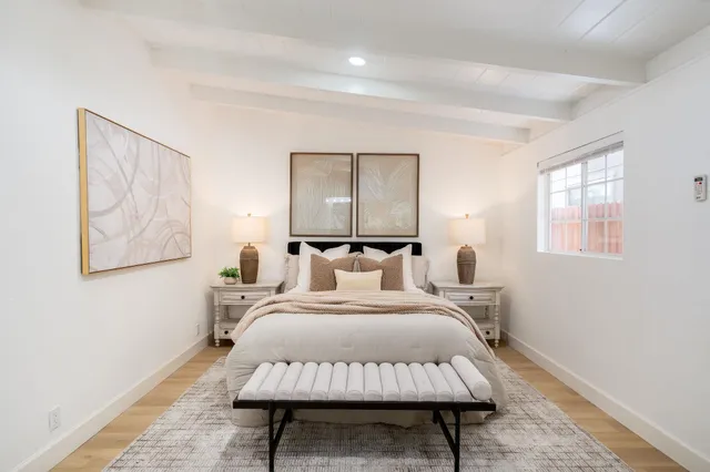 a bedroom with a bed and a potted plant