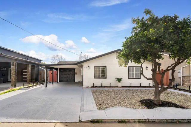a view of a house with backyard and sitting area