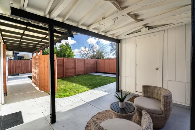 a view of backyard with potted plants and wooden fence