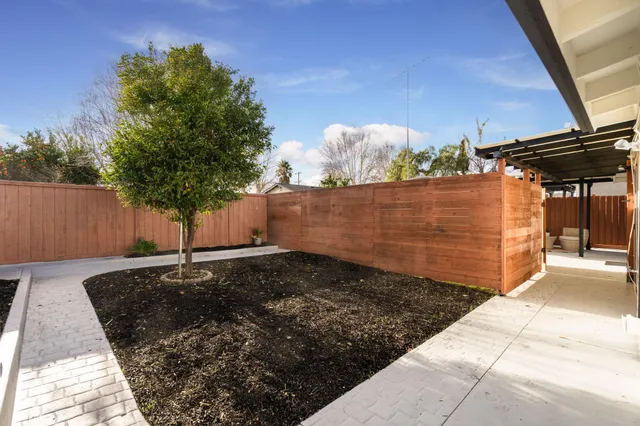 a front view of a house with yard and trees