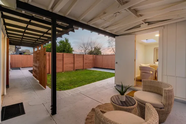 a view of a patio with table and chairs a barbeque with wooden fence