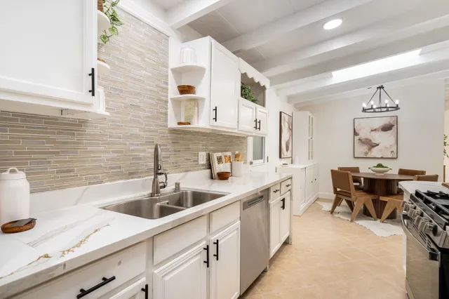 a kitchen with stainless steel appliances a sink stove top oven and cabinets