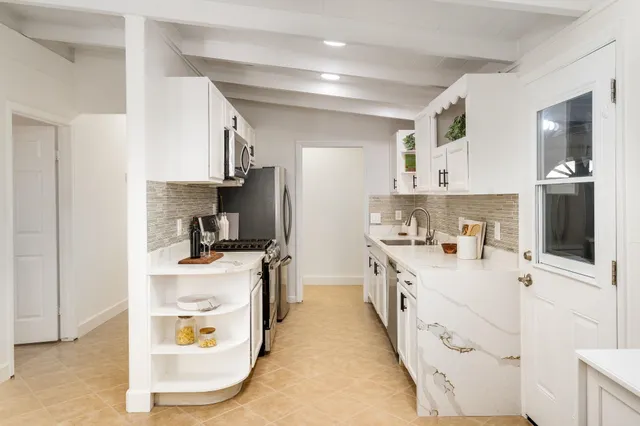 a view of a dining room with furniture a kitchen and wooden floor