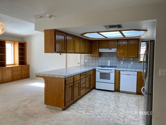 718 North Inyo Street Ridgecrest, CA 93555 - Photo 3 of 9 a kitchen with stainless steel appliances granite countertop a sink and a stove