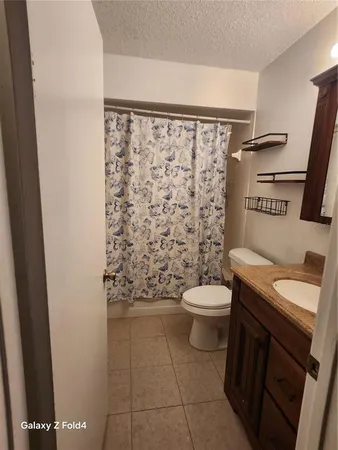 a bathroom with a granite countertop toilet sink and a shower