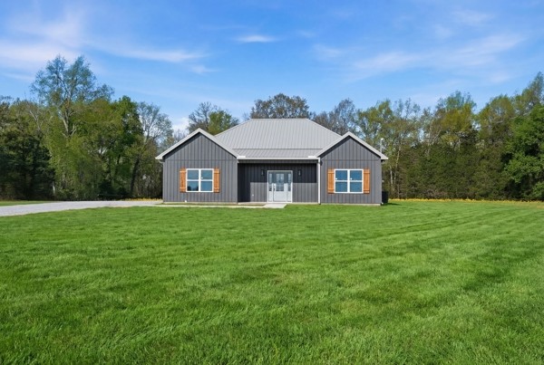 a front view of a house with a yard and trees