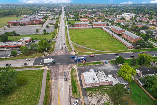 an aerial view of a city with lots of residential buildings ocean and mountain view in back