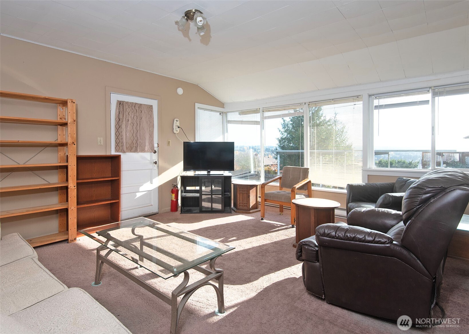 705 South 208th Street Des Moines, WA 98198 - Photo 12 of 20 a living room with furniture a flat screen tv and a floor to ceiling window