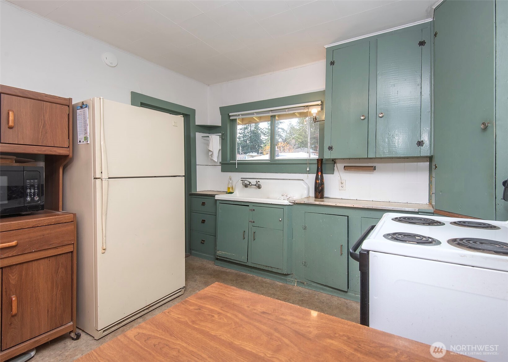 705 South 208th Street Des Moines, WA 98198 - Photo 17 of 20 a kitchen with a refrigerator sink stove and cabinets