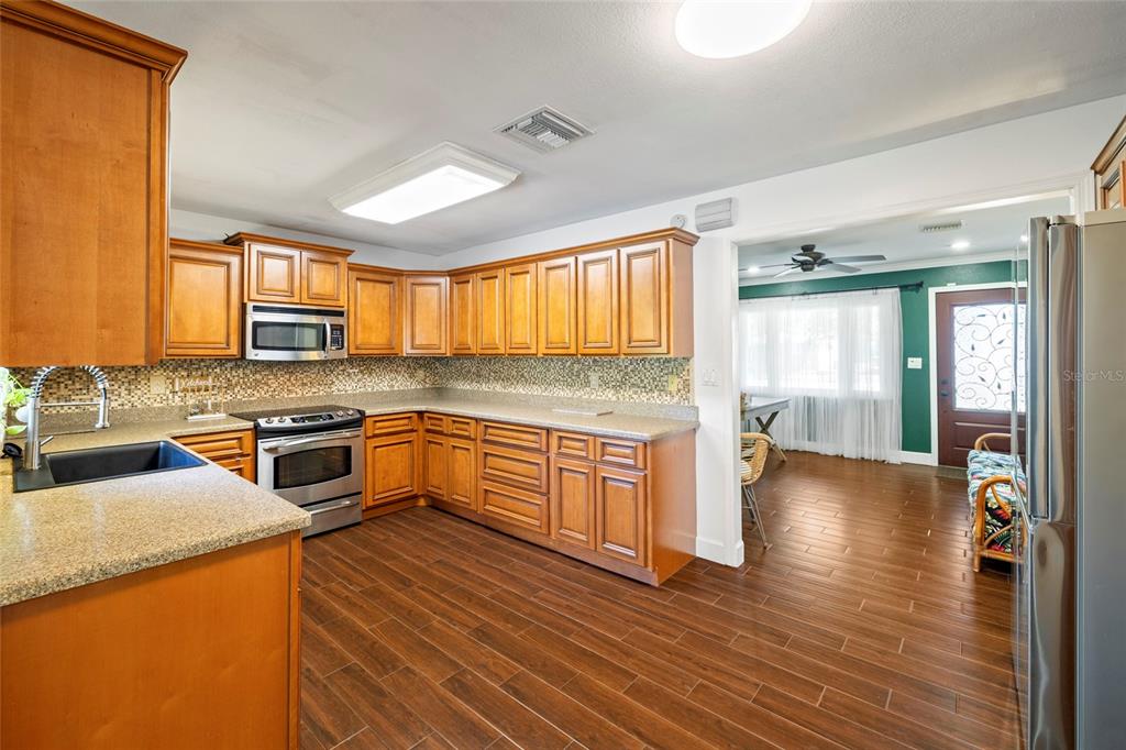 5031 Lakewood Road Sebring, FL 33875 - Photo 13 of 77 a kitchen with granite countertop wooden floors and stainless steel appliances