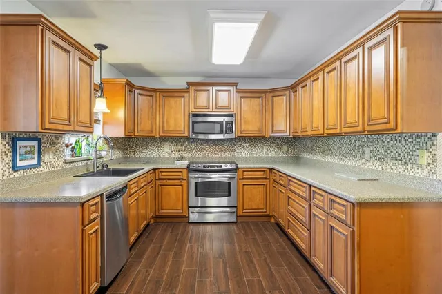 a kitchen with stainless steel appliances wooden floors and large window