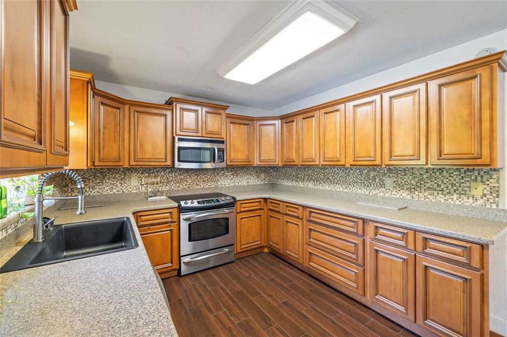 5031 Lakewood Road Sebring, FL 33875 - Photo 15 of 77 a kitchen with stainless steel appliances granite countertop wooden cabinets a sink and dishwasher with wooden floor