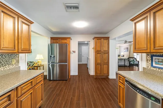 a kitchen with stainless steel appliances granite countertop a refrigerator and a sink