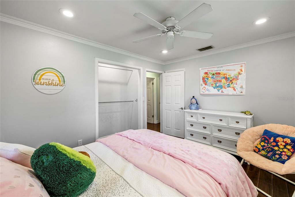 5031 Lakewood Road Sebring, FL 33875 - Photo 28 of 77 a bedroom with a bed a chandelier and a painting on the wall