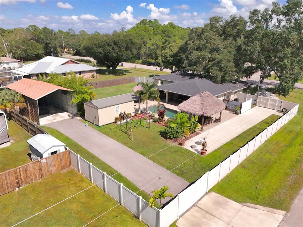 5031 Lakewood Road Sebring, FL 33875 - Photo 75 of 77 a view of a swimming pool with lawn chairs under an umbrella