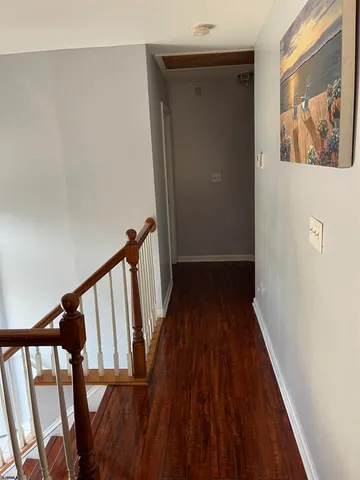 a view of a hallway with wooden floor and staircase