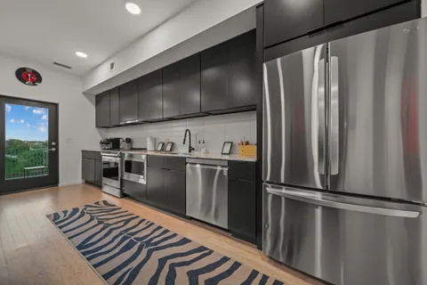 a kitchen with stainless steel appliances a refrigerator and a stove top oven